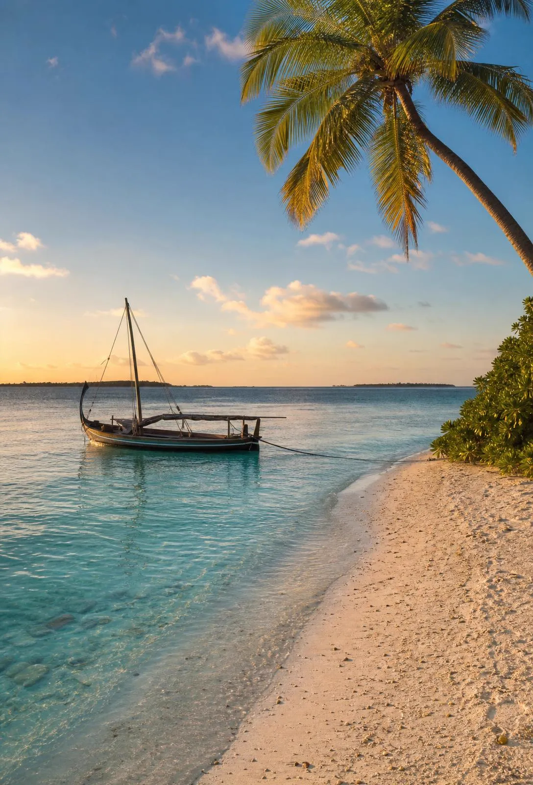 Isla local de Maldivas al atardecer con dhonis y aguas turquesa